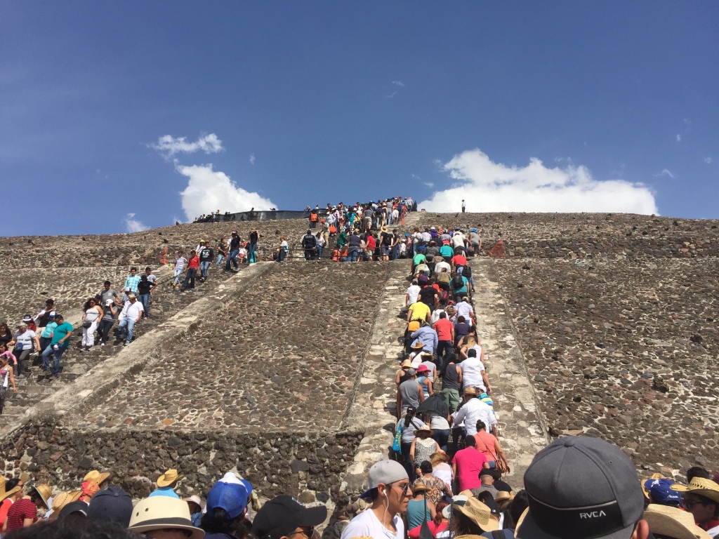 A line of tourists winds up the steps of the pyramid of the sun at Teotihuacan.