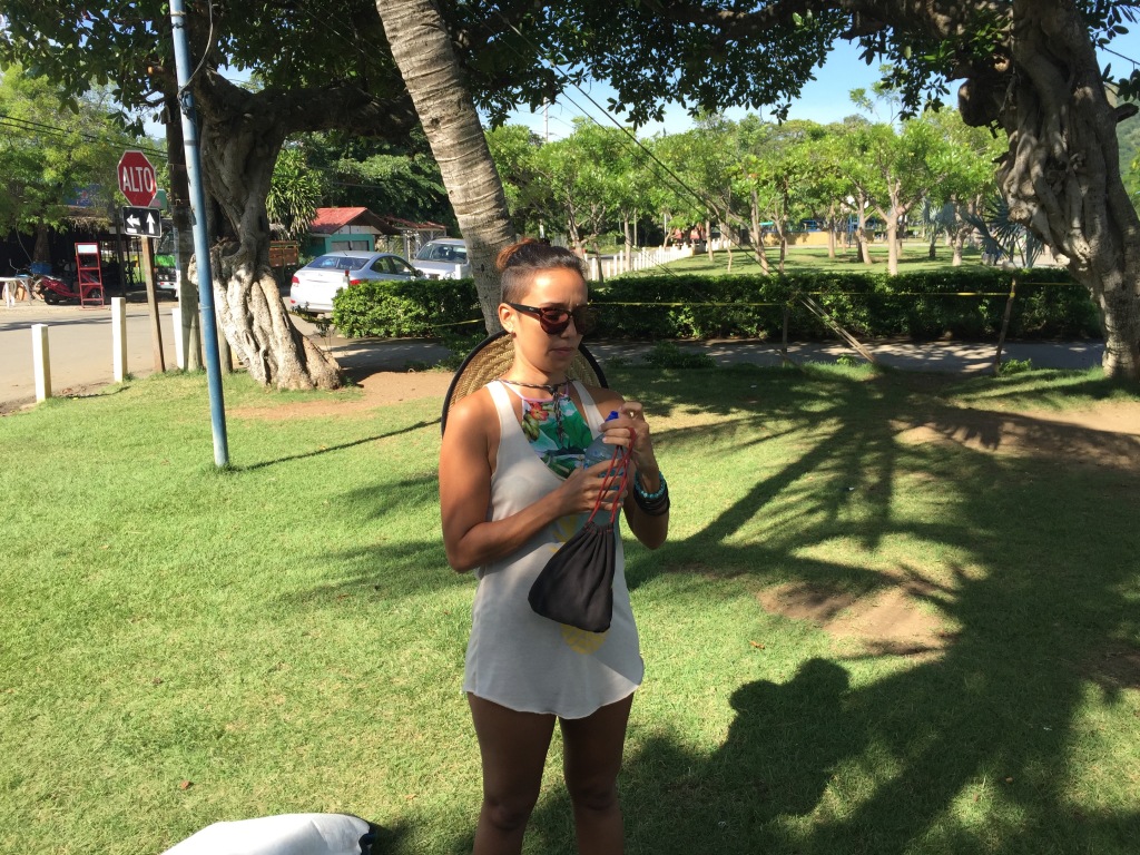 Lois Solano opens a bottle of water on a grass lawn in Costa Rica.