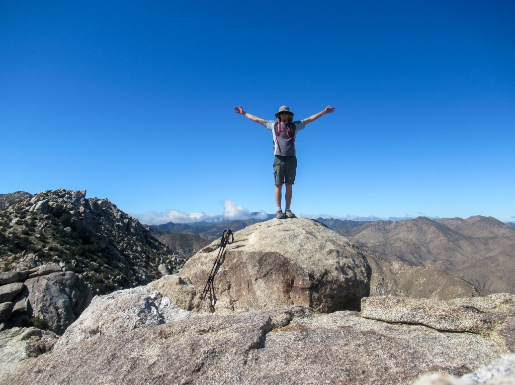 Evan Quarnstrom spreading his arms on the top of San Ysidro Mountain East.